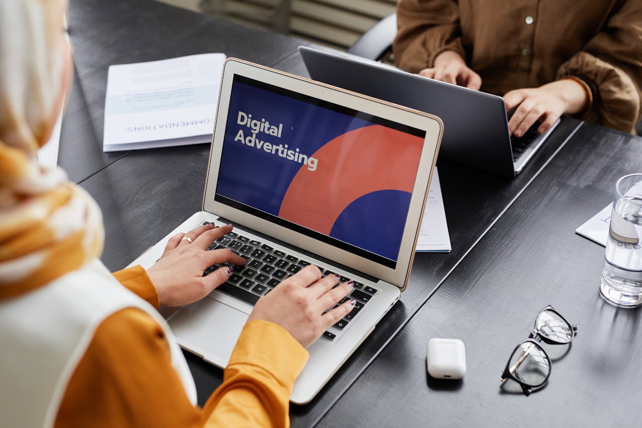 Mastering the First Impression: Your intriguing post title goes here Two professionals work on laptops focusing on digital advertising in an office setting.